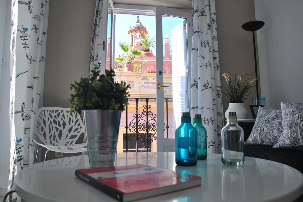 a table with two bottles on a table with a window at Iberflat Fabiola in Seville