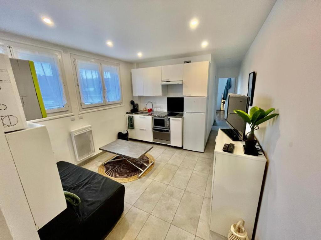 a kitchen with white cabinets and a stove top oven at Le canoe in Vaires-sur-Marne