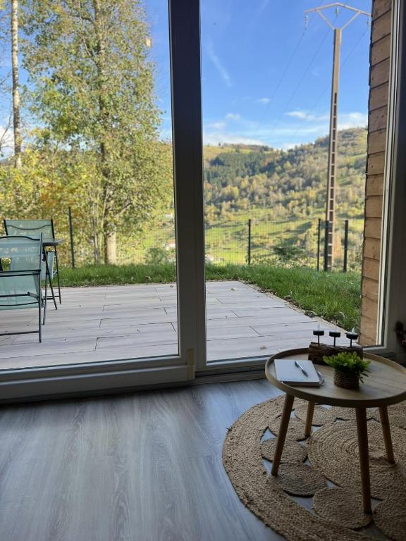 - un salon avec une grande porte coulissante en verre et une table dans l'établissement Appartement calme La Bresse animaux admis, à La Bresse