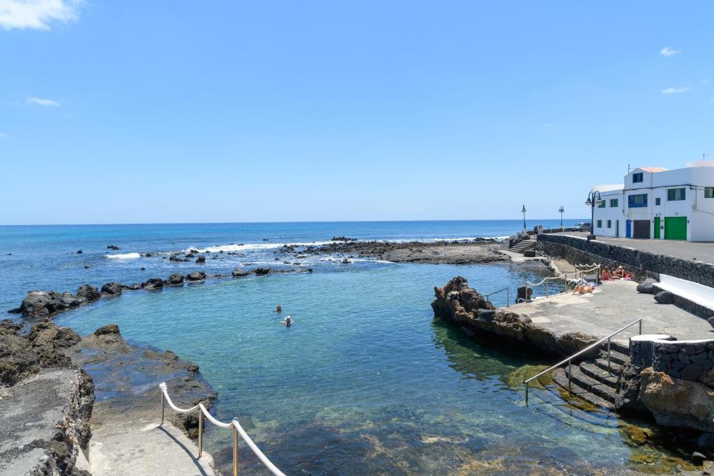 a beach with people swimming in the water at Casa Costa Jameos in Punta de Mujeres