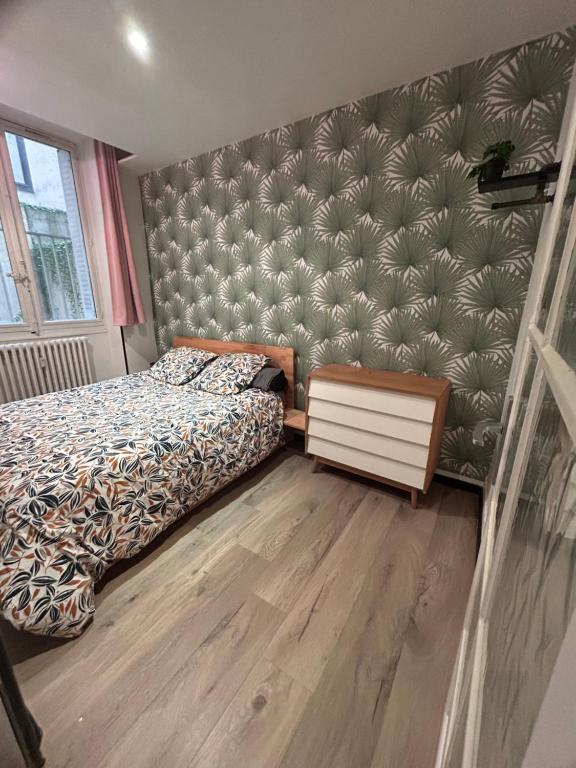 une chambre avec un lit et un mur dans l'établissement Hypercentre Chambéry, à Chambéry