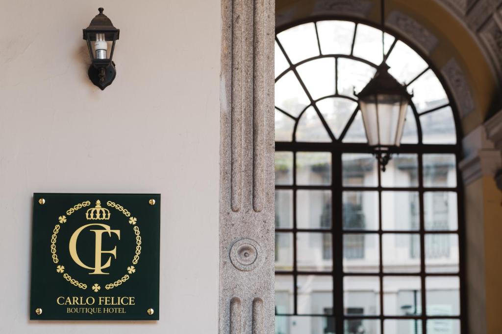 a sign on a pole next to a window at Carlo Felice Boutique Hotel in Turin