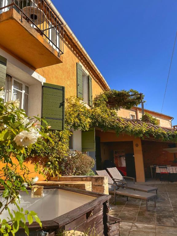 - un bâtiment avec un balcon, une table et des bancs dans l'établissement Les 3 Terrasses, à Roussillon