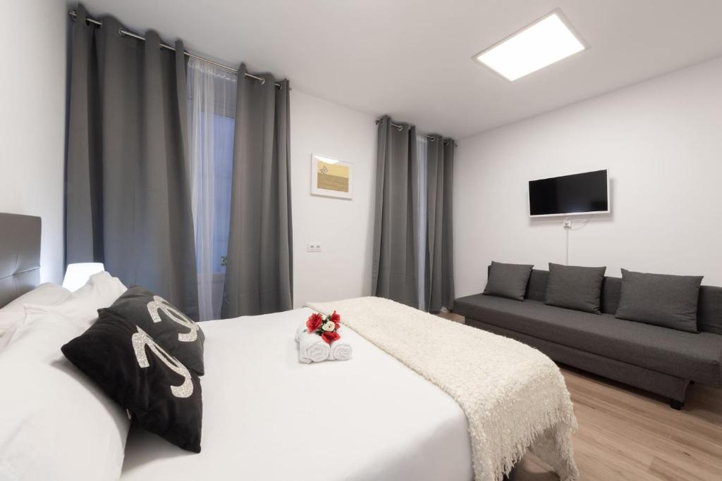A bed or beds in a room at Apartamentos Day Madrid SANTO DOMINGO Centro Gran Via Sol Malasaña