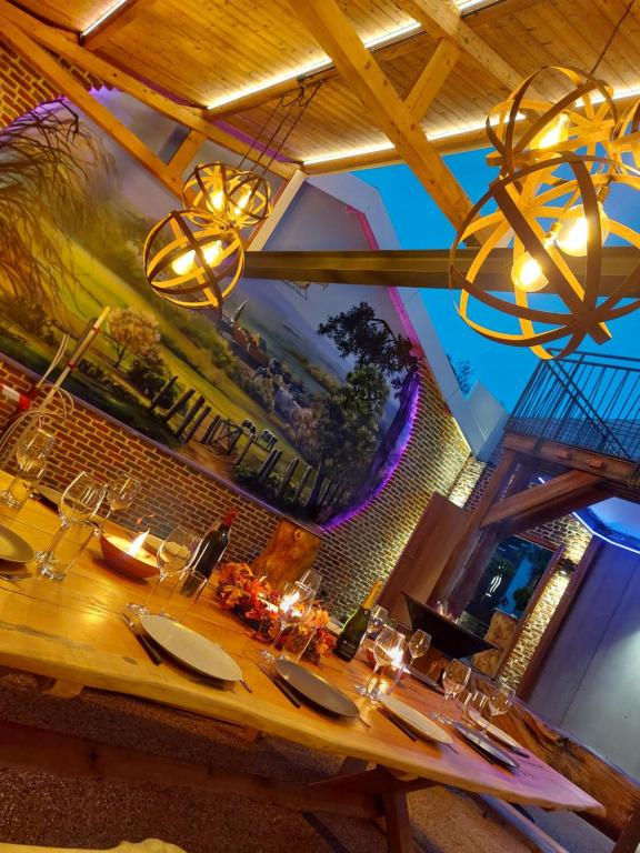 a dining table in a restaurant with a chandelier at La Renaissance - Deux gites de standing in Herve