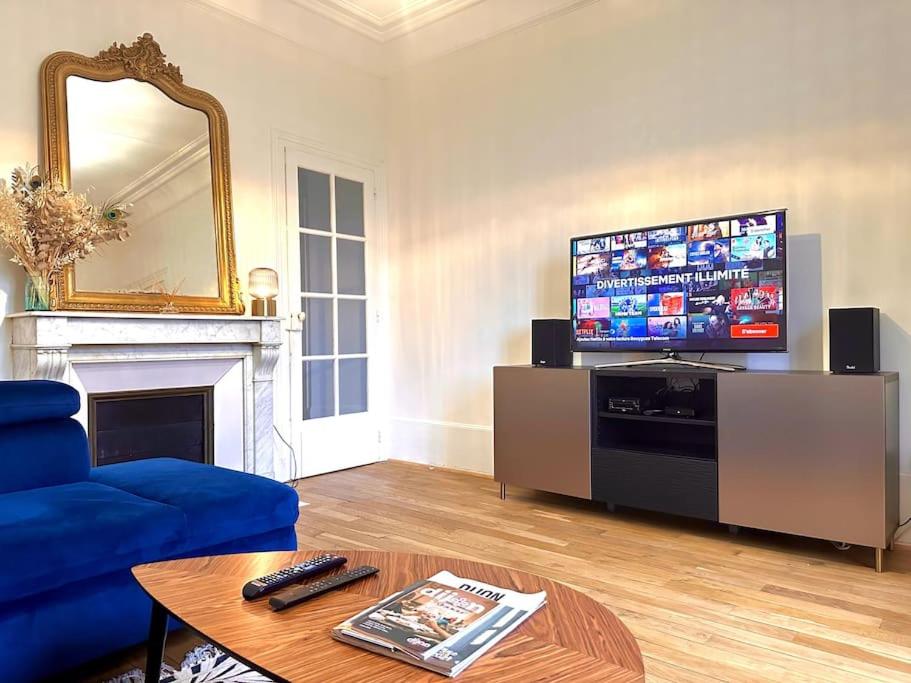 un salon avec un canapé bleu et une télévision dans l'établissement La Duchesse de Bourgogne, à Dijon