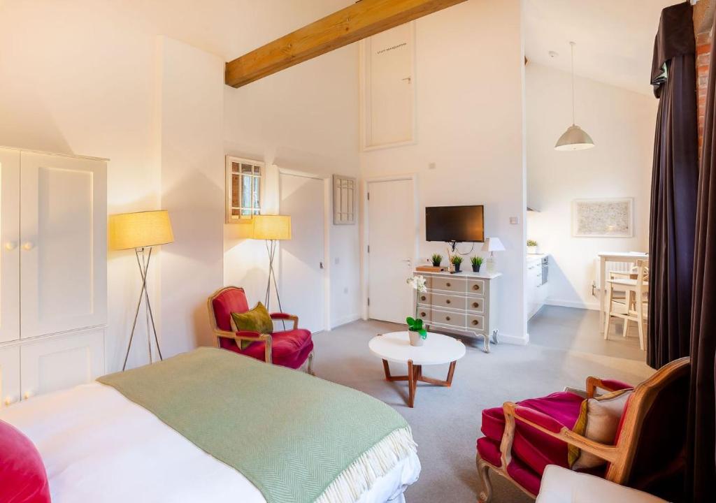 een slaapkamer met een bed en een woonkamer bij Rotheram (Suite) at Bicester Heritage in Bicester