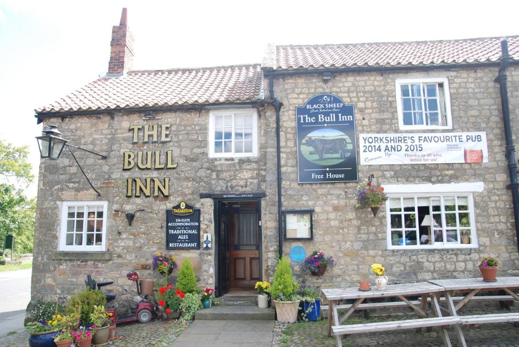 ein Gebäude mit einem Schild, das den Gasthof liest in der Unterkunft The Bull Inn West Tanfield in Ripon