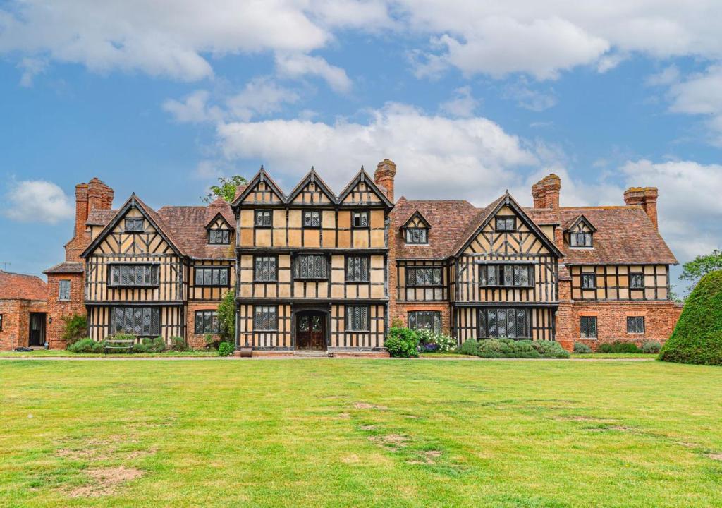 una casa grande con un gran patio de césped en Severn End - 15th Century Manor House!, en Hanley Castle