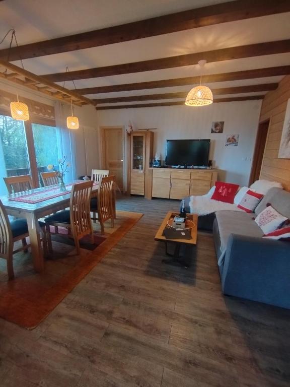 un salon avec un canapé et une table dans l'établissement Chalet au bois des écureuils classé trois étoiles., à Muhlbach-sur-Munster