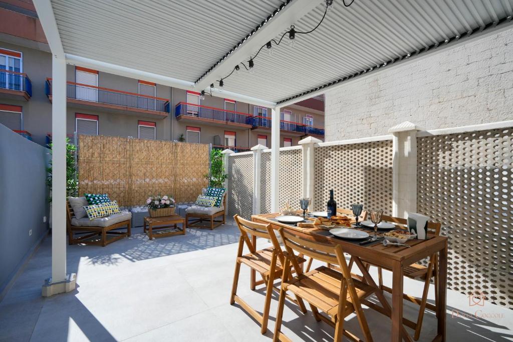 a patio with a table and chairs and a building at Downtown Apartments Dolci Coccole The Terrace in Bari