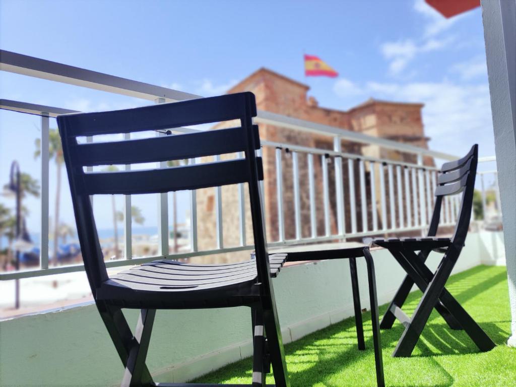 a black chair sitting on top of a balcony at Los Deseos De Vera in La Cala de Mijas