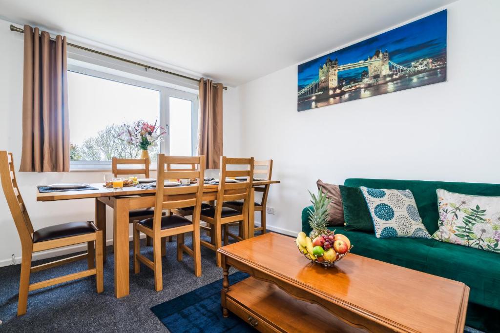 a living room with a table and a green couch at Mayflower 5-Bed Home, Contractors, Family Xmas, Harry Porter in Hemel Hempstead