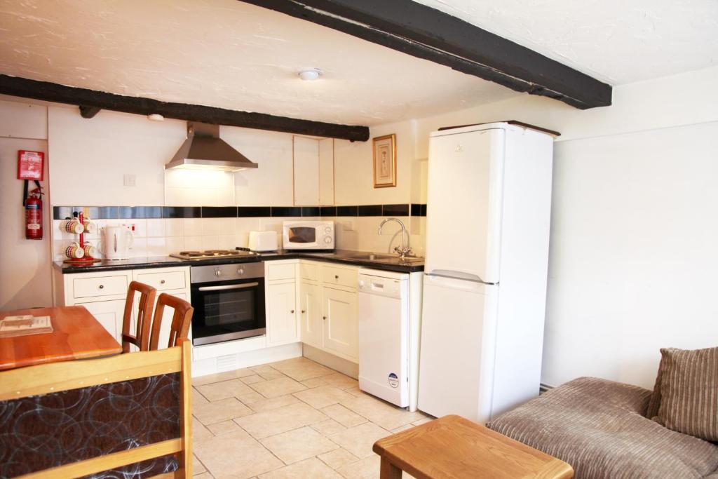 uma cozinha com um frigorífico branco e uma mesa em Sheephouse Manor em Maidenhead