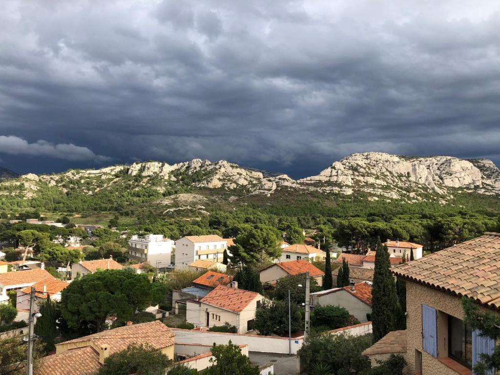 a town with houses and mountains in the background at L’appartement - Jardin Secret in Marseille