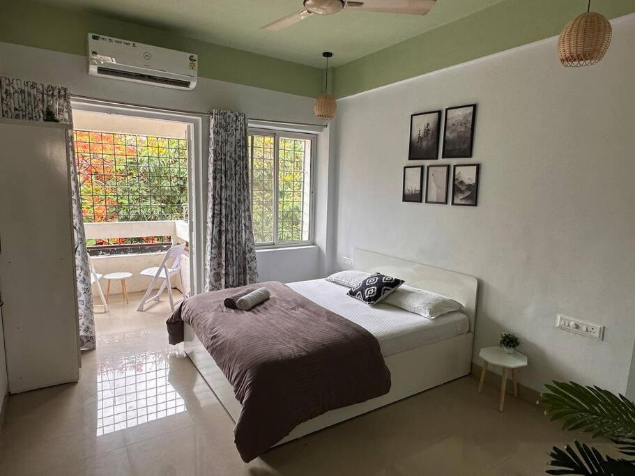 a bedroom with a bed in a room with a piano at Ozone Pvt Studio Apt with Balcony in Koregaon Park Near Osho Ashram in Pune