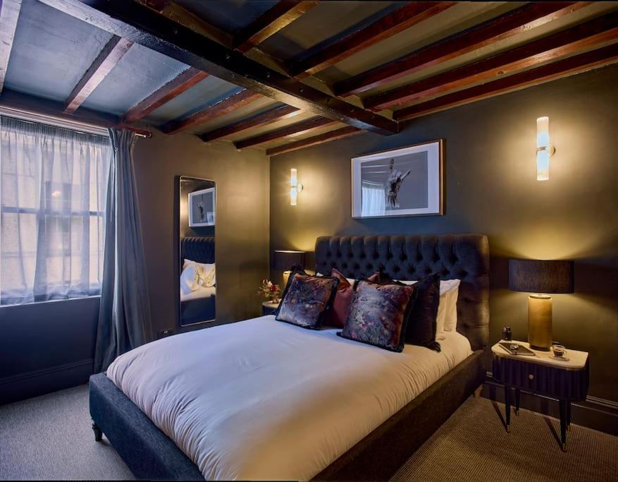 a bedroom with a large bed and a window at The Knitters House - Luxury 3 Bedroom Property in Nottingham