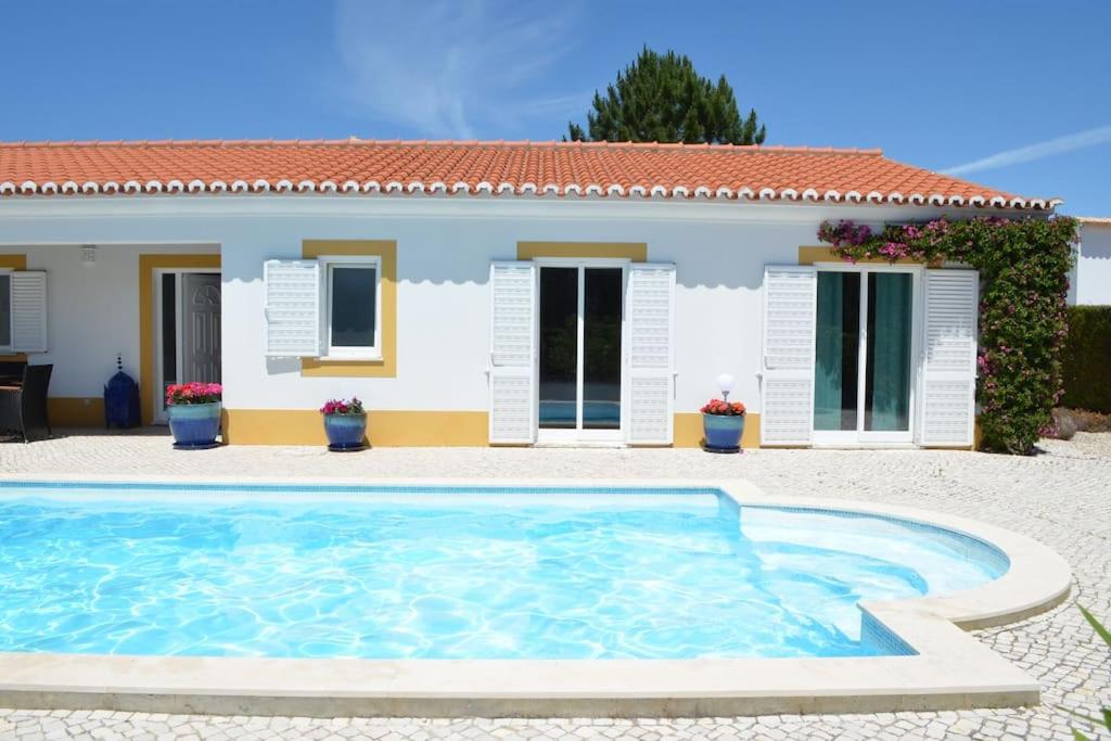 a villa with a swimming pool in front of a house at Wanderlust - Beautiful Villa in Aljezur in Aljezur