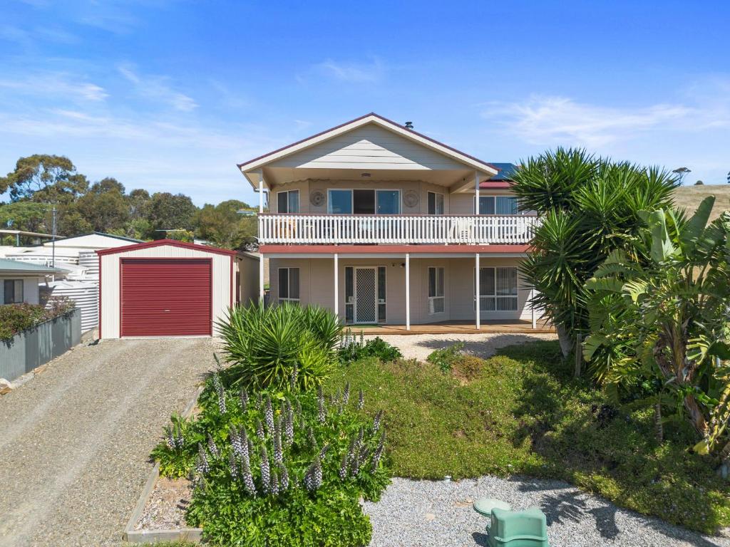 una casa con garaje rojo y palmeras en Valley Views - 11 Woodgate Road, en Second Valley