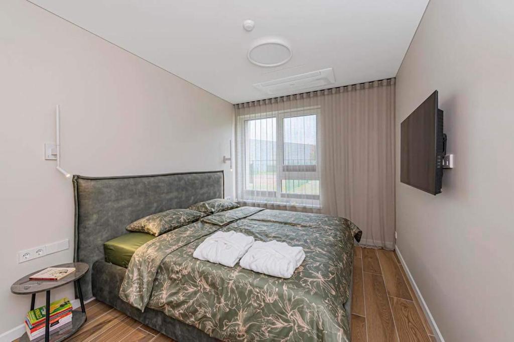 une chambre avec un lit avec deux serviettes dessus dans l'établissement Birstonas Rent, à Birštonas