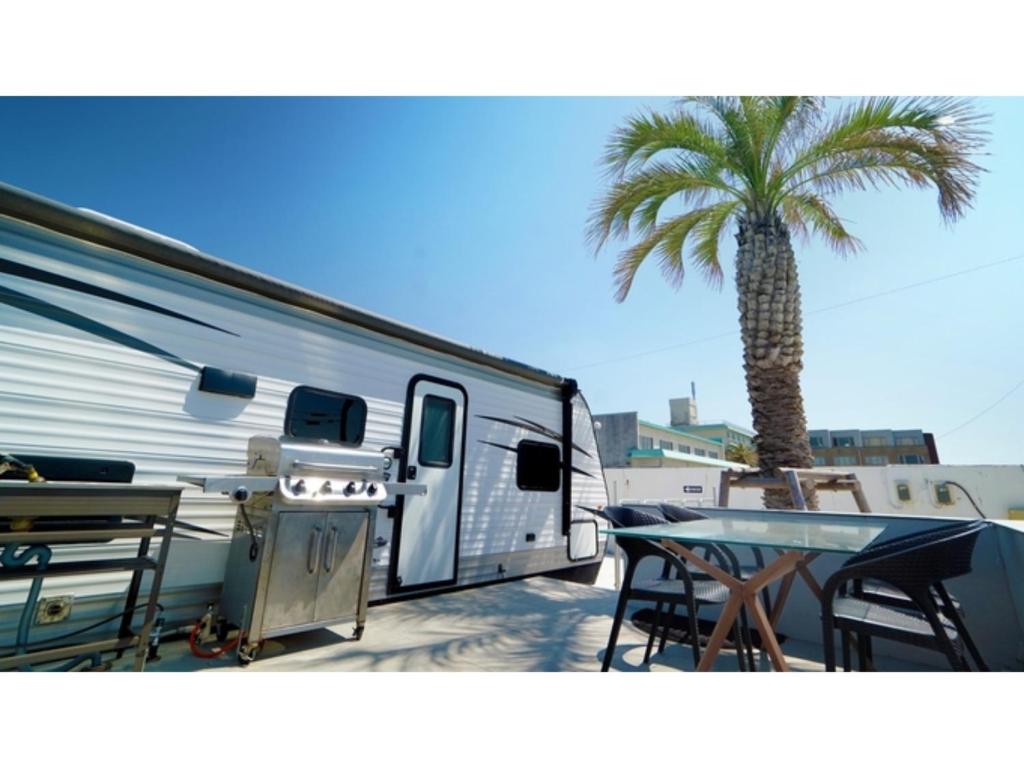 an rv parked next to a palm tree and a table at OCEAN FRONT TATEYAMA - Vacation STAY 37303v in Tateyama