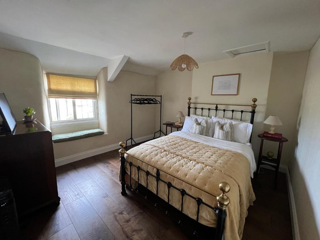 a bedroom with a large bed and a window at Rosebank Cottage in Boscastle