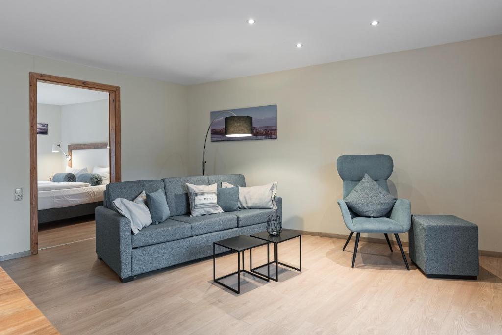 a living room with a couch and a chair at Anders & Meer ANDERS & MEER App Weite in Sankt Peter-Ording