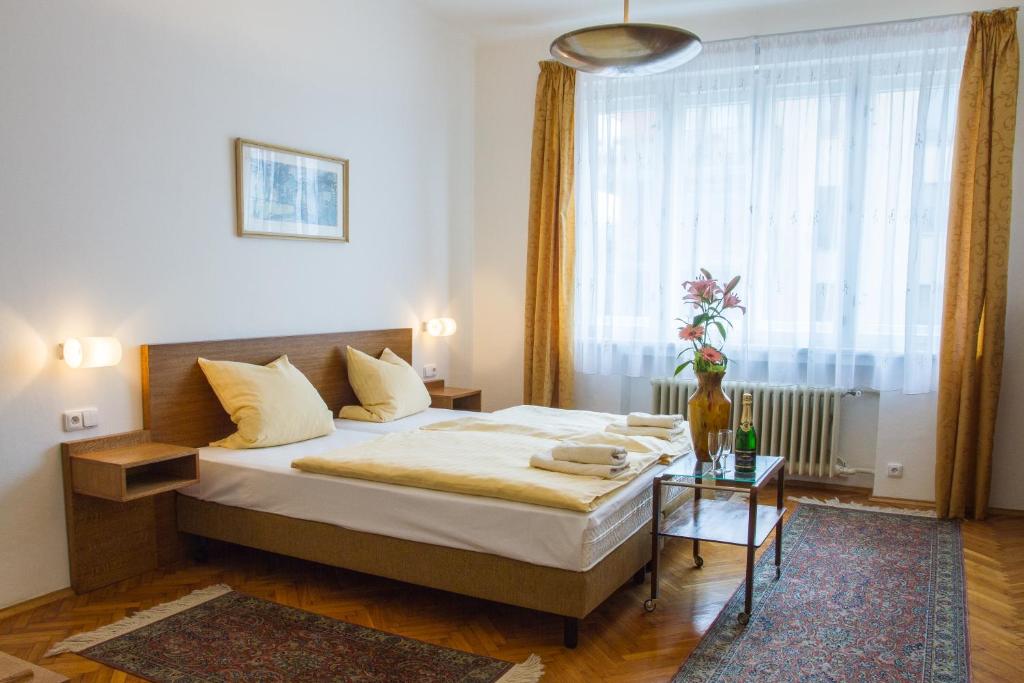 a bedroom with a bed and a large window at Pension Karnet in Prague