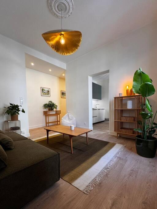a living room with a couch and a table at Les Dunes Appartement Cosy 200m de la mer in Le Touquet-Paris-Plage