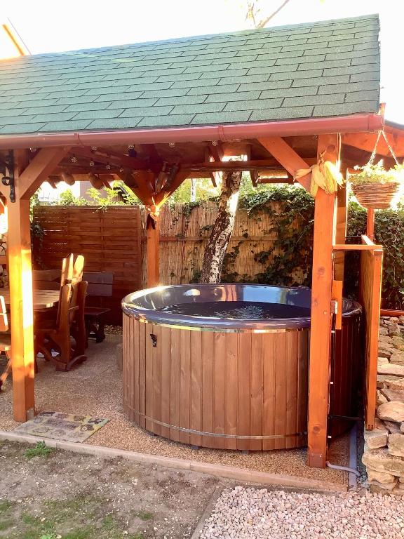 drewniana altana z jacuzzi pod nią w obiekcie Rita Apartman w Gyenesdiás