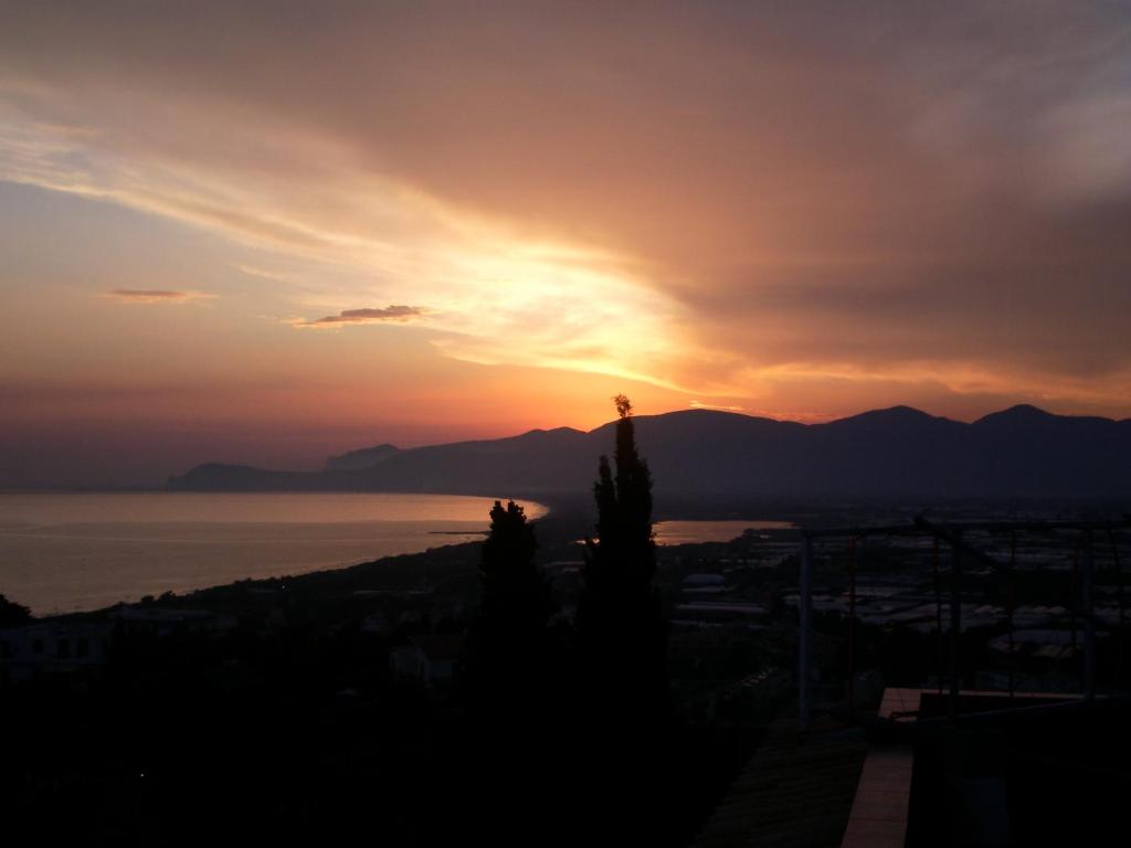 a sunset over the ocean with mountains in the background at Hotel Belvedere in Sperlonga