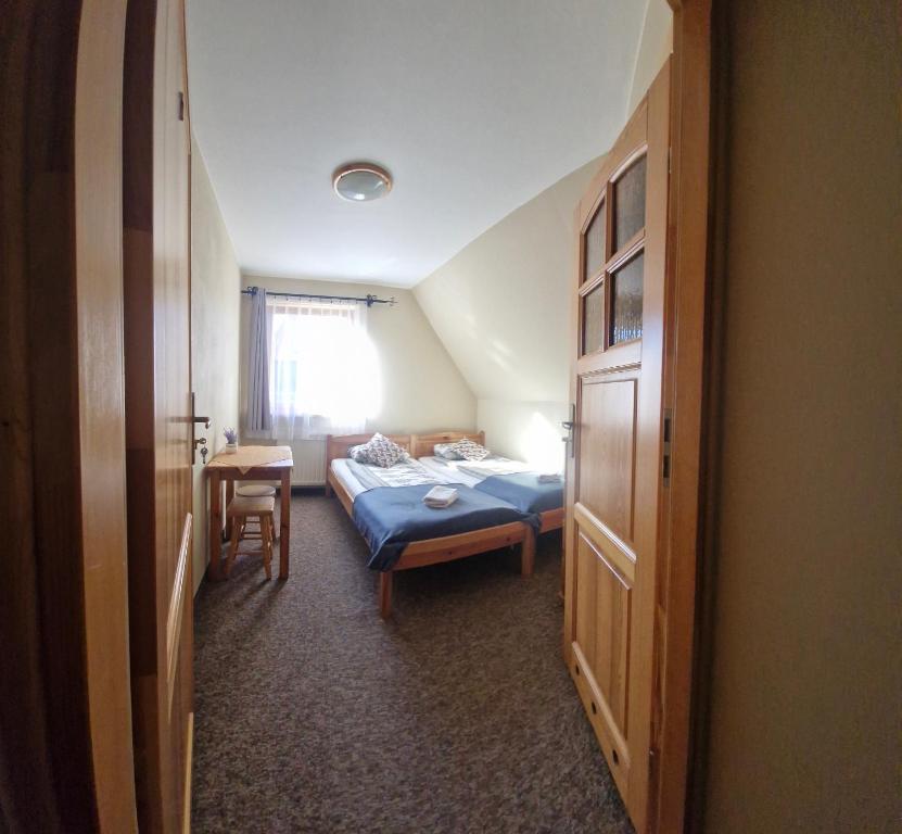 a bedroom with a bed and a table and a chair at Willa nad Potokiem in Zakopane