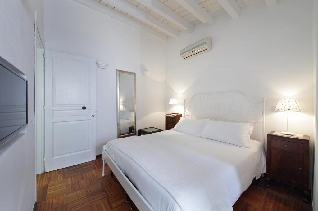 een witte slaapkamer met een wit bed en een raam bij B&B Five Rooms in Siracusa