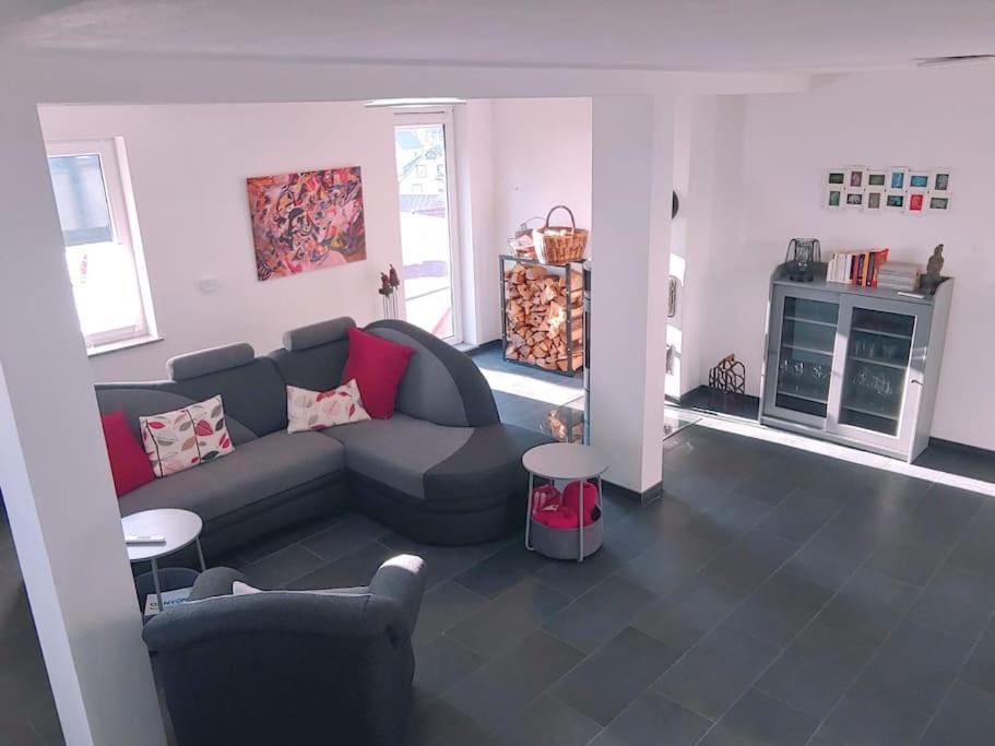 a living room with a couch and a table at Ruhiges Ferienhaus mit viel Platz und Ladestation für E-Auto in Masserberg