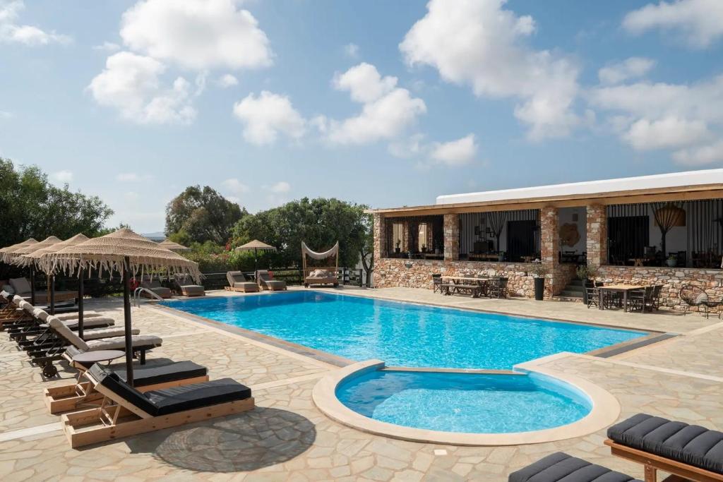 a swimming pool with lounge chairs and a resort at Parosland Hotel in Aliki