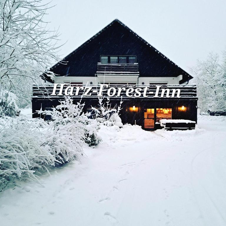 a snow covered building with a sign that reads happy forest inn at Harz-Forest-Inn in Goslar