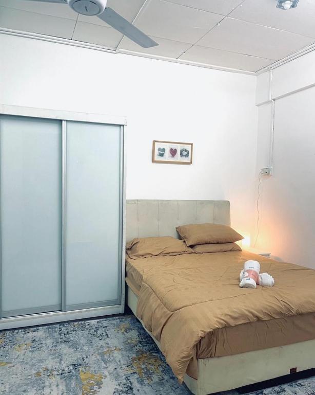 Un dormitorio con una cama con un osito de peluche encima. en Yawang homestay, en Kota Bharu