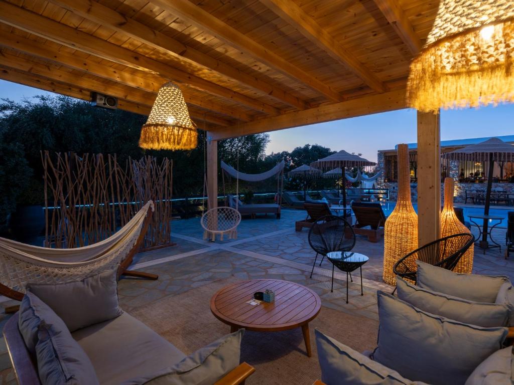 a patio with couches and chairs and a table at Parosland Hotel in Aliki