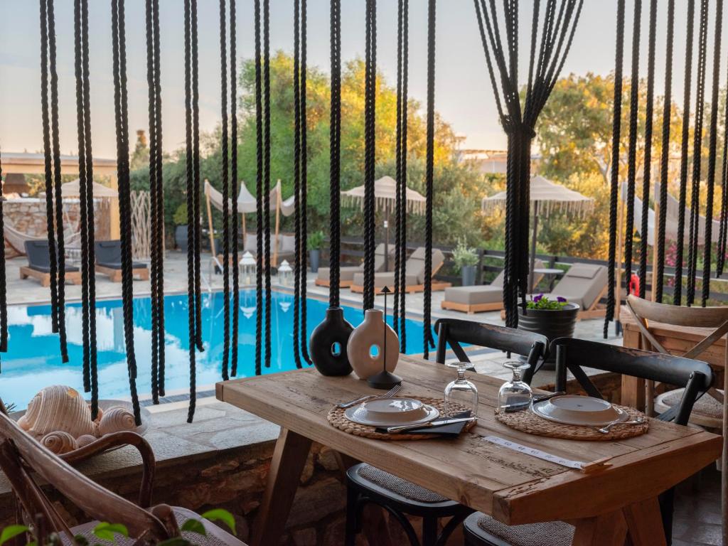 a wooden table sitting next to a swimming pool at Parosland Hotel in Aliki