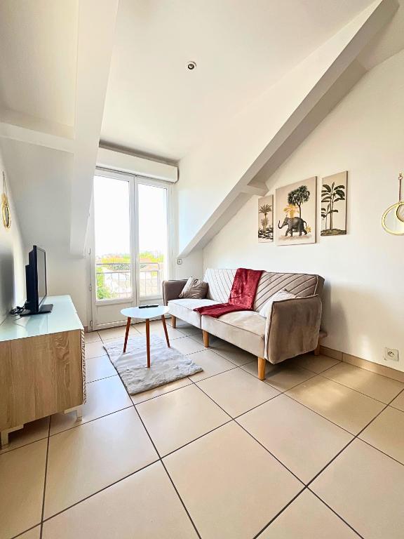 un salon avec un canapé et une table dans l'établissement Duplex-Trois pas de la Gare, à Sartrouville