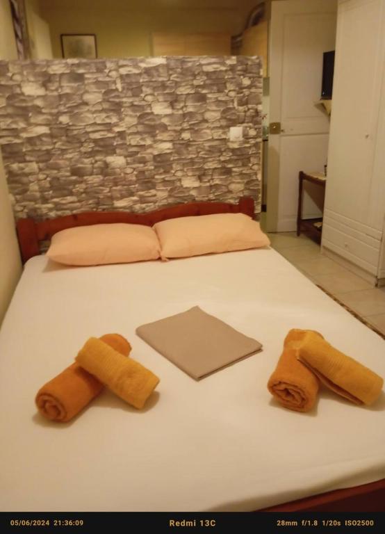a bed with three brown towels on it at Villa Vitta picola casa in Nafpaktos