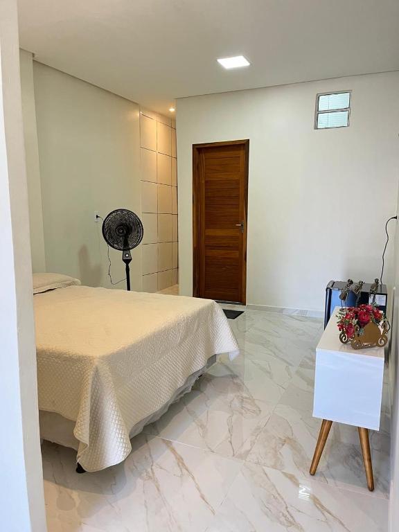 a bedroom with a bed and a table with flowers on it at Flat com quarto e sala in Viçosa do Ceará