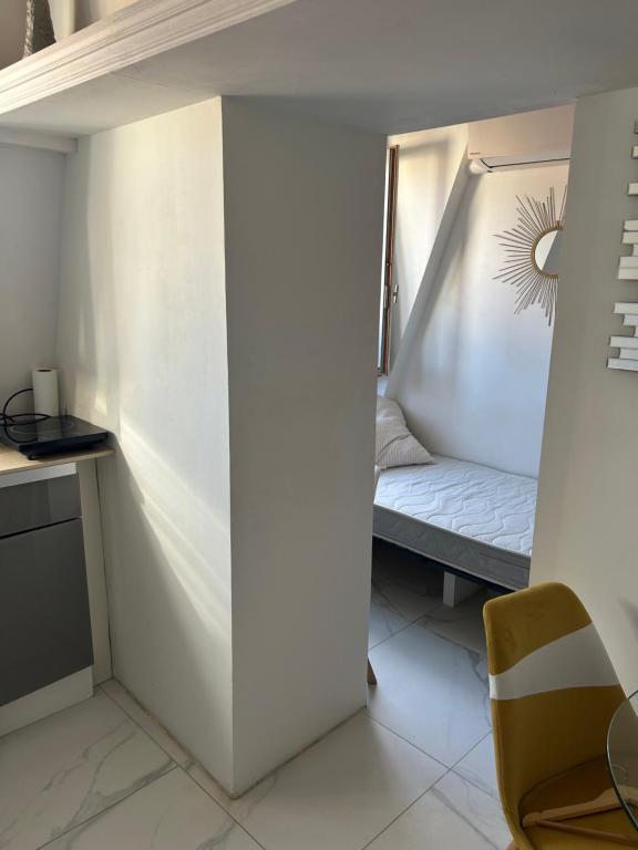 une petite pièce avec un lit et une chaise dans l'établissement Studio centre Nice, à Nice