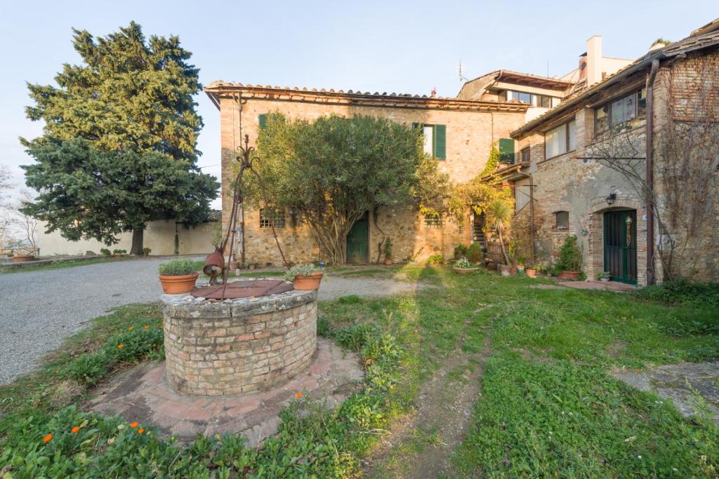 una antigua casa de piedra con un patio con plantas en Agriturismo Santa Croce en San Gimignano