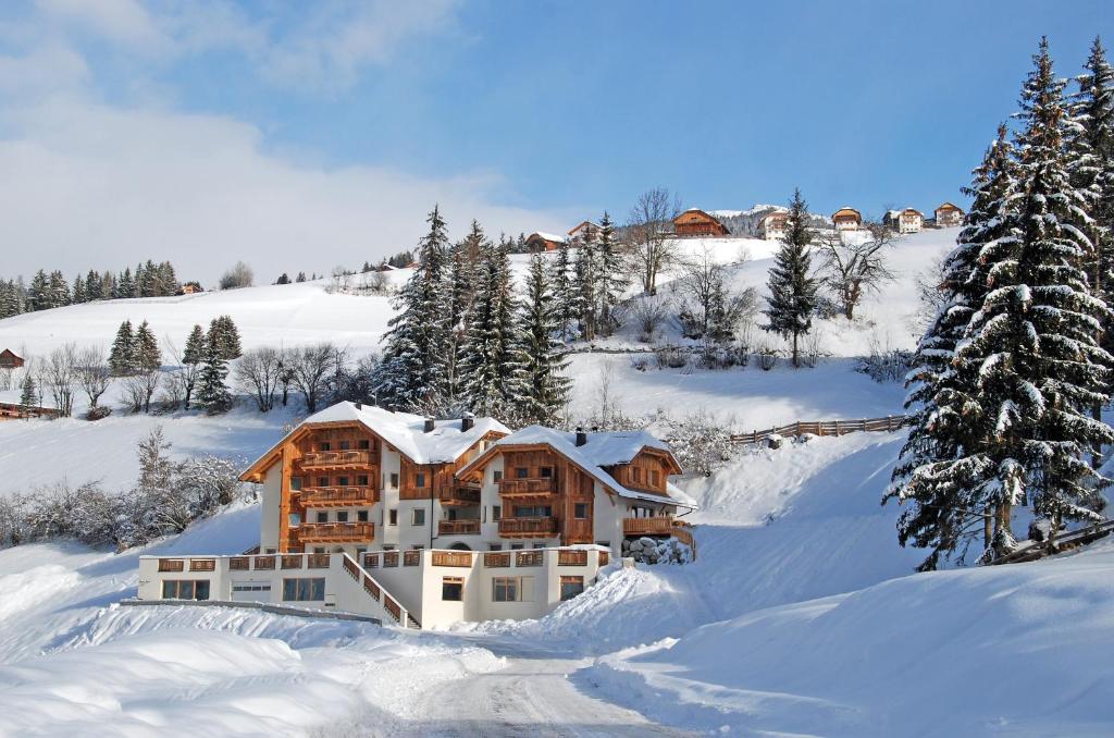 una casa nella neve con alberi innevati di Residence Baron a San Vigilio Di Marebbe