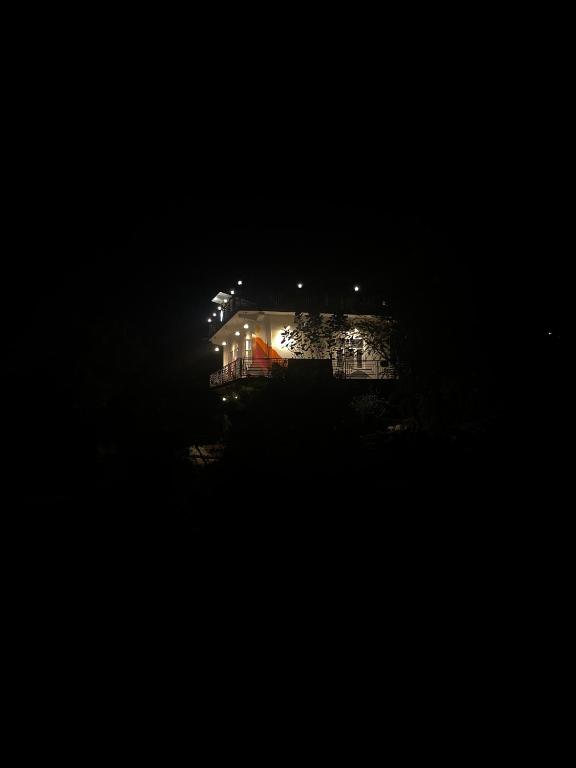 a house at night with lights in the dark at Akaasa homes in Baijnāth