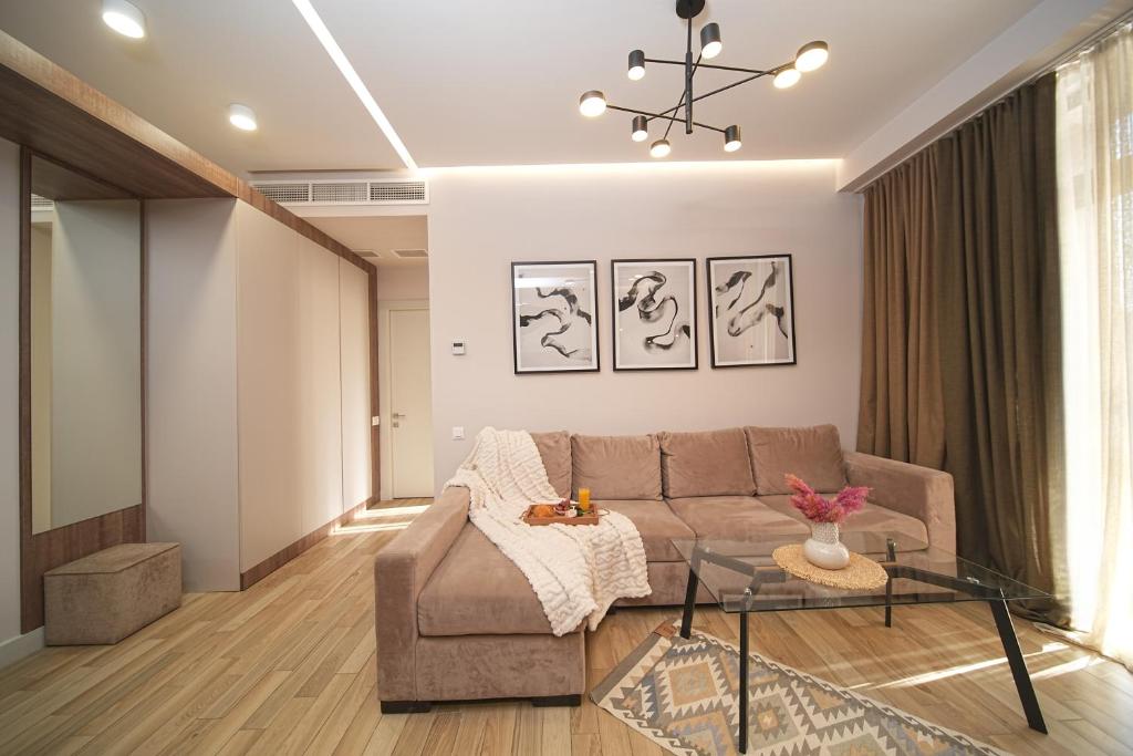 Una sala de estar con un sofá y una mesa de cristal. en Sweet Home Deluxe Apart-Hotel, en Ereván