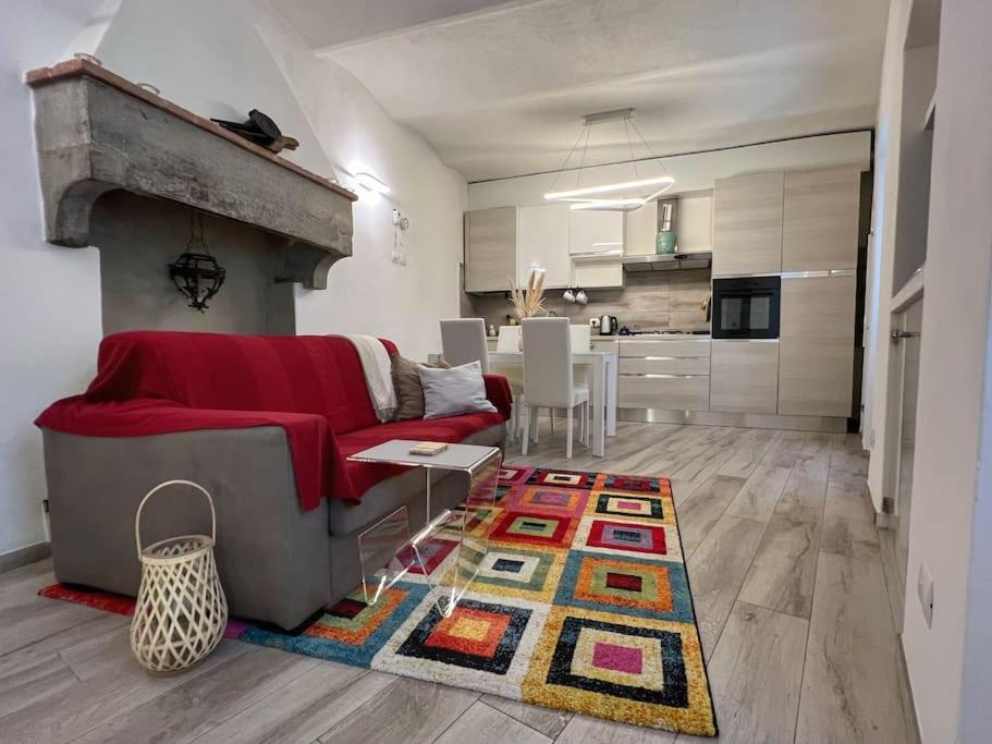 Una sala de estar con un sofá rojo y una cocina. en Tolletta 10eLode, en Arezzo