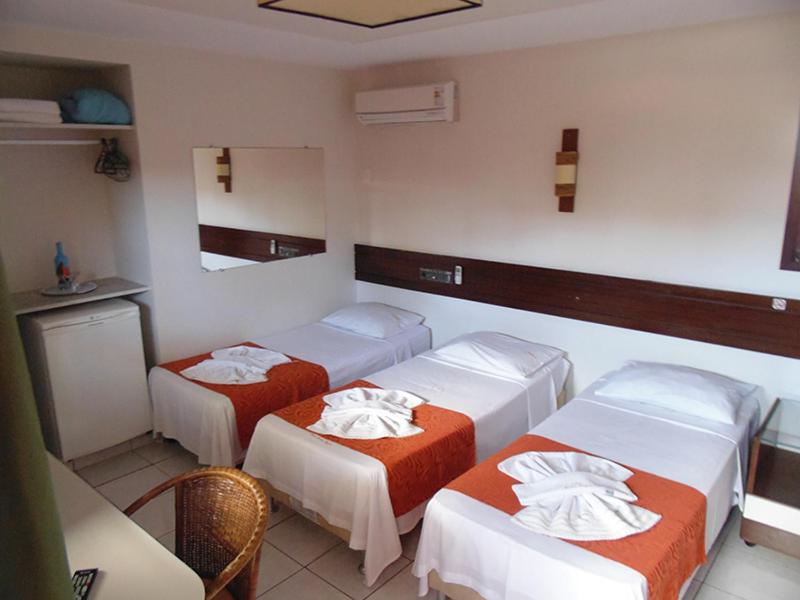 a room with three beds in a room at Pousada Solar Ponta Negra in Natal