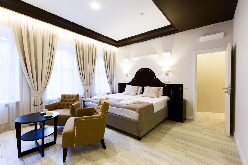 1 dormitorio con cama, sofá y mesa en Hotel Dalisi, en San Petersburgo